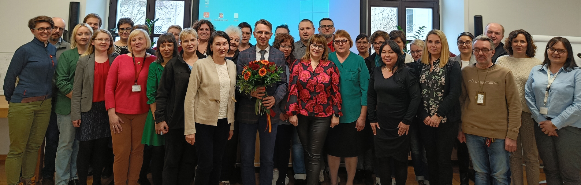 Zdjęcie grupowe wszystkich pracowników Archiwum, pośrodku Dyrektor dr Sławomir Marchel z kwiatami
